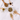 Assorted wooden spoons filled with loose Organic Detox Tea ingredients arranged around a glass jar on a white marble surface.