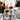 Two cups of Organic Relieve Stress Tea served with a white teapot, surrounded by lavender sprigs, flowers, and loose leaf tea in a wooden jar on a marble surface.