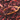 Close-up of dried hibiscus petals with deep red and magenta hues, spilling from a wooden scoop onto a pile of loose hibiscus tea