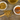 A cup of Organic Chamomile Tea with dried chamomile flowers on a wooden spoon, a small bowl of honey with a honey dipper, and a rustic wooden surface beneath.