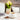White ceramic mug with tea, teapot, and flowers on a wooden table