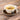 White teacup with tea leaves and a 'Inspiring Tea' tag on a wooden surface