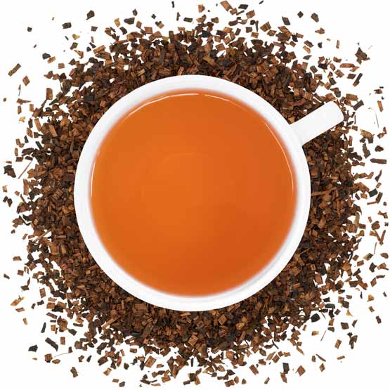 A white mug filled with Honeybush tea with honeybush herbs spread around it. 