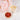 Bowl of goji berries with a glass of white tea and pink flowers on a marble surface