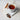White mug of holiday cheer tea with star anise on a marble surface, surrounded by cinnamon sticks and star anise.