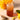 Glass of iced tea with a straw, surrounded by lemons, ginger, and a wooden spoon with tea leaves on a light background.