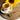 Teacup with tea, sunflower, and spoonful of dried oregano on a wooden surface