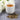 White cup of Pai Mu Tan tea with dry leaves and white flowers on a gray surface