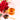 Glass of rosehips tea with a spoonful of rosehip leaves and red flowers on a light pink background