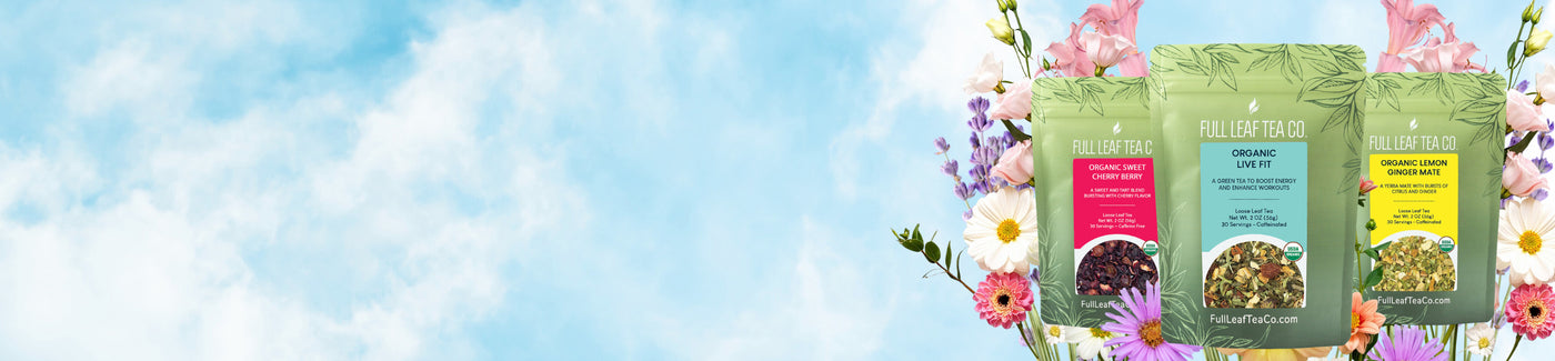 Three green tea packages with colorful labels against a blue sky and floral background