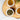 Two cups of tea and a bowl of dry sencha tea leaves on a wooden board.
