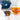 Blue teapot, glass cup with tea, and scattered Thai tea leaves on a white surface