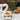 Tea cup with floral design on a white surface, surrounded by a green tea canister, ginger root, and cinnamon sticks.