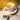 Tea cup with floral design, wooden spoon, and valerian root on a wooden surface.