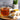 Glass of vertigo relief tea on a wooden board with bowls of spices and a plant in the background
