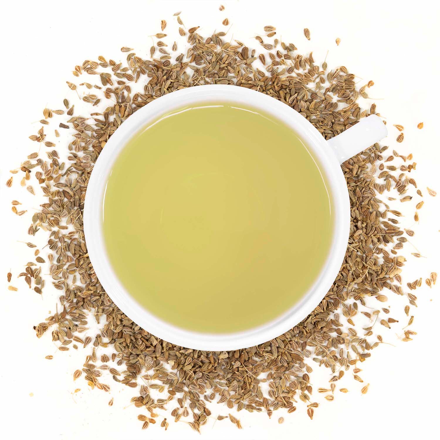 A white mug filled with Anise seed tea surrounded by anise seeds
