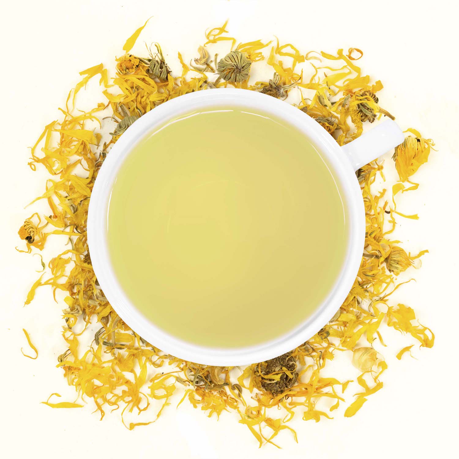 A white mug filled with calendula tea surrounded by calendula
