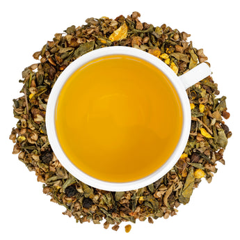 A white cup of Organic Decaf Anti-Inflammatory Tea surrounded by the loose leaf blend.