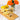 Clear glass mug with tea, wooden spoon, lemons, and orange roses on a marble surface