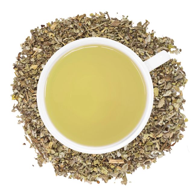 A white cup of Organic Sage tea, surrounded by the loose leaf tea.